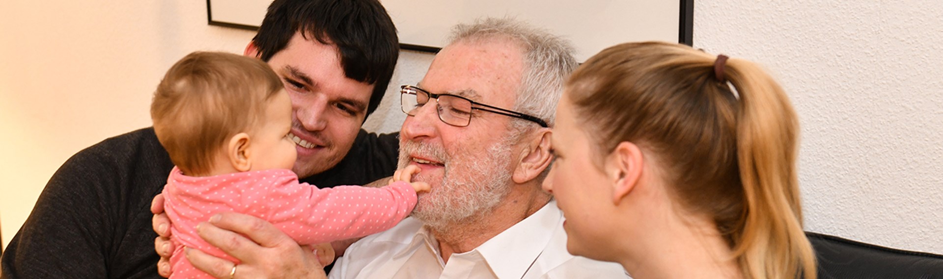 Großvater, junge Eltern und Baby spielen